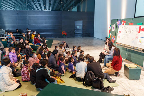 写真 としょかん・メディアテークフェスティバルで親子連れへの絵本の読み聞かせの様子